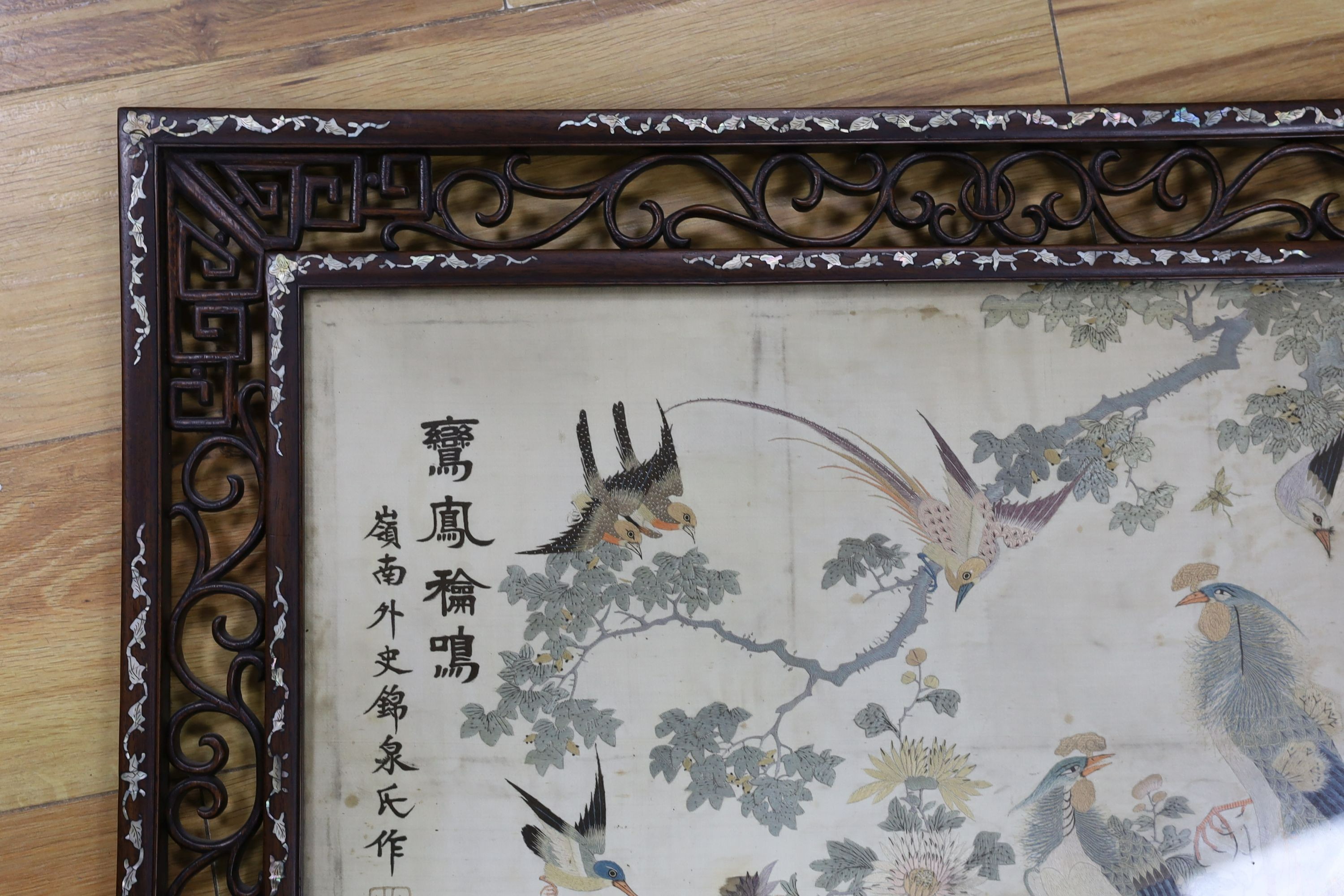 A Chinese mother of pearl inlaid framed and inscribed silk embroidery ‘of the hundred birds’, 78cms wide, 59cms high (including frame)